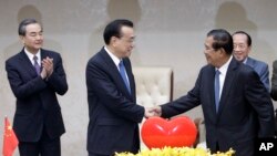 지난 11일 캄보디아 프놈펜의 평화궁전에서 리커창 중국 총리(왼쪽)와 훈센 캄보디아 총리가 양국의 경제협력과 관련한 20가지 협약에 동의하는 서명식을 가진 후
악수하고 있다.