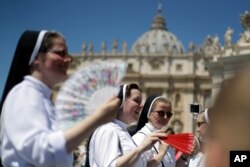 Nuns use fans to cool-off in St. Peter's Square at the Vatican, June 30, 2019.