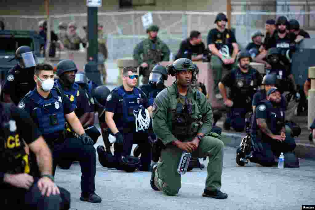 Officers kneel with protesters during a protest against the death in Minneapolis in police custody of African-American man George Floyd, in Downtown Atlanta, Georgia, June 1, 2020.