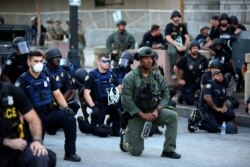 Officers kneel with protesters during a protest against the death in Minneapolis in police custody of African-American man George Floyd, in Downtown Atlanta, Georgia, U.S. June 1, 2020.