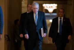 Senate Majority Leader Mitch McConnell, R-Ky., walks to the chamber as lawmakers negotiate on the emergency coronavirus response legislation, at the Capitol in Washington, March 18, 2020.