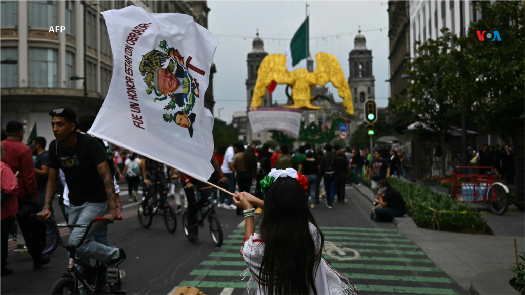 Una niña ondea una bandera que representa al presidente mexicano Andrés Manuel López Obrador, antes de la ceremonia del &#39;Grito de Independencia&#39;, que marca el inicio de las celebraciones del Día de la Independencia cerca de la Plaza El Zócalo en la Ciudad de México.