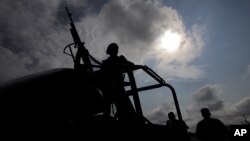 Military personnel are silhouetted while keeping watch at the perimeter of an area evacuated because of a gas leak caused by a pipeline theft in Puebla, Mexico, Sept. 12, 2018. A similar presumed fuel theft in 2017 left 10 dead and 13 detained with excessive force by the military, which is accused of human rights violations.