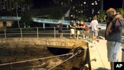 People watch the water recede from Hobron Harbor in Honolulu on March 11, 2011. Tsunami waves swamped Hawaii beaches before dawn Friday but didn't cause any major damage after devastating Japan.