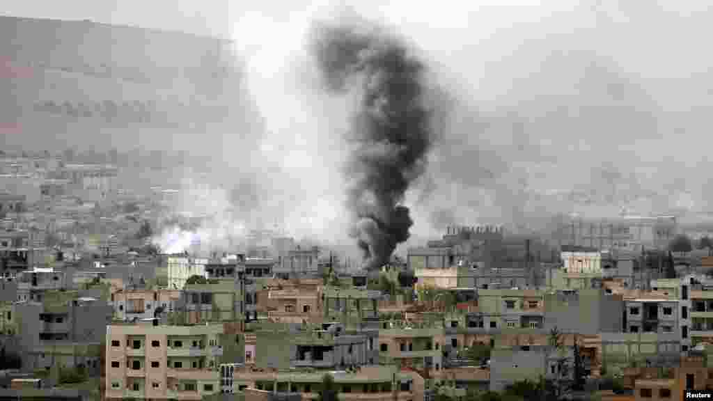 O fumo mancha o céu da cidade síria de Kobani, vista da fronteira de Mursitpinar, entre a Síria e a Turquia, na cidade de Suruc, província de Sanliurfa, Out. 12, 2014. 