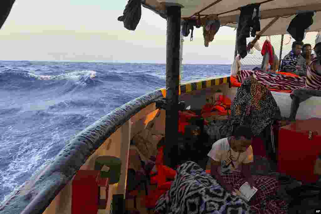 گروهی از مهاجران در دریای مدیترانه و یکی از آنها در حال قرائت قرآن. اروپا برنامه جدیدی برای پذیرش این مهاجران دارد. آنها به ایتالیا میروند.&nbsp;