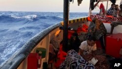 Para migran yang diselamatkan oleh kapal kemanusiaan "Open Arms" berada di perairan dekat Pulau Lampedusa, Italia. 