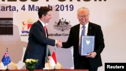 Indonesia's Trade Minister Enggartiasto Lukita and Australia's Minister of Trade, Tourism and Investment Simon Birmingham shake hands after signing an economic partnership agreement aimed at boosting trade and investment, March 4, 2019, in Jakarta.