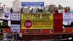 Cambodian non-governmental organization (NGOs) activists shout slogans during a protest against a proposed Don Sahong dam, in a tourist boat along the Tonle Sap river, in Phnom Penh, file photo. 