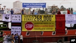 Cambodian non-governmental organization (NGOs) activists shout slogans during a protest against a proposed Don Sahong dam, in a tourist boat along the Tonle Sap river, in Phnom Penh, file photo. 