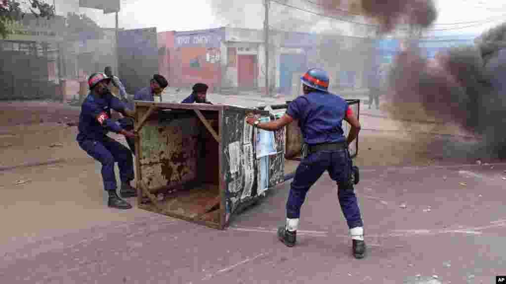 La police esssaie de débarasser la voie publique des barricades érigées par des manifestants.