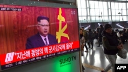 People walk past a television news broadcast at a railway station in Seoul on Jan. 1, 2017, showing North Korean leader Kim Jong-Un's New Year's speech.