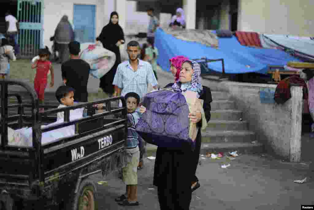 A family leaves a United Nations-run school sheltering displaced Palestinians in the east of Khan Younis in the southern Gaza Strip, Aug. 27, 2014.