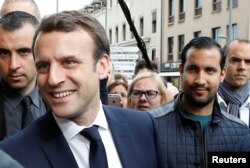 FILE - Emmanuel Macron, left, is campaigns for the 2017 presidential election, flanked by Alexandre Benalla, right, head of security, in Rodez, France, May 5, 2017.