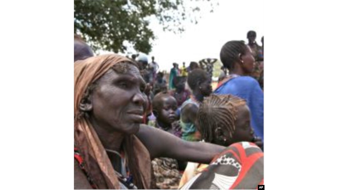 People wait at the food distribution center set up by the World Food Program in Gumuruk, 40 kilometers from Pibor, South Sudan, January 17, 2012.