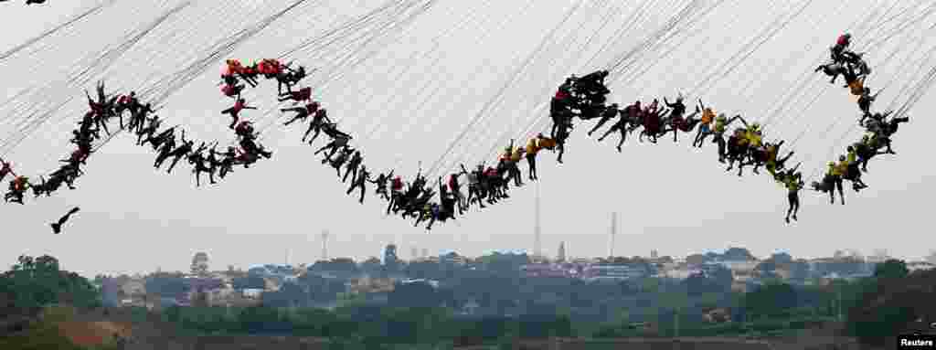 People jump off a bridge, which has a height of 30 meters, in Hortolandia, Brazil, Oct. 22, 2017.