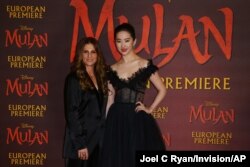 Actress Yifei Liu, right, and Director Niki Caro, left, pose for photographers upon arrival at the European Premiere of 'Mulan' at a central London cinema, March 12, 2020.