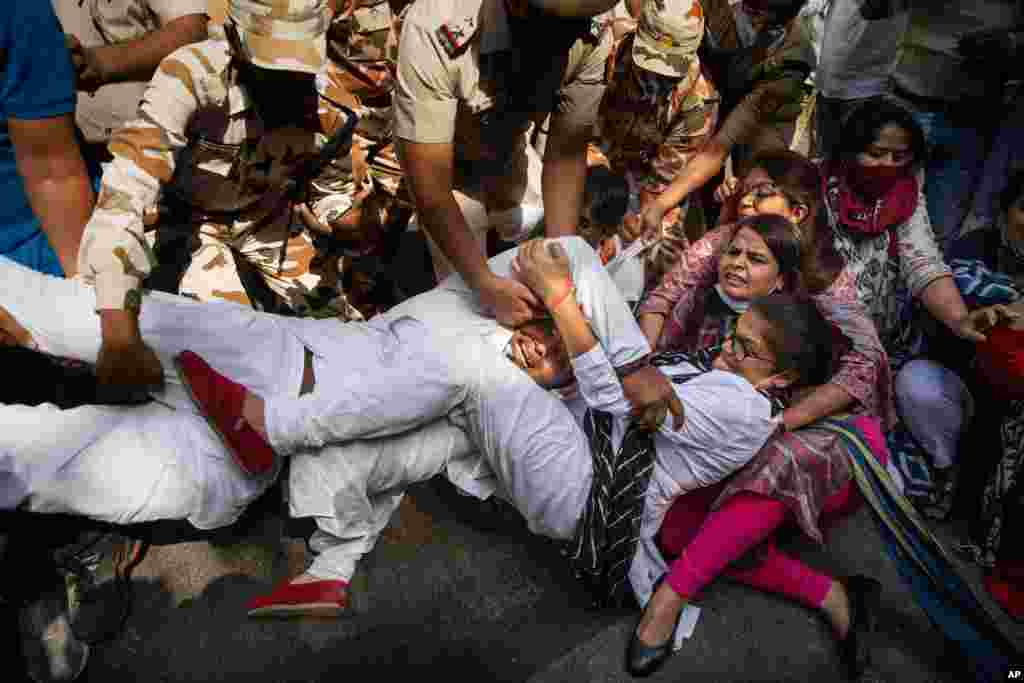 India&#39;s opposition Congress party supporters protesting against the gang rape and killing of a woman in Uttar Pradesh’s Hathras district hold onto each other as policemen try to detain them in New Delhi.