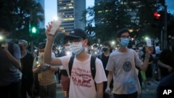 香港示威者在抗议活动中打开手机闪光灯游行。（2020年6月9日）