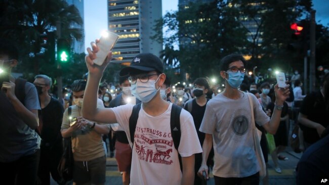 香港示威者在抗议活动中打开手机闪光灯游行。（2020年6月9日）