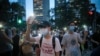 Pro-democracy demonstrators march holding their phones with flashlights on during a protest to mark the first anniversary of a mass rally against the now-withdrawn extradition bill in Hong Kong, June 9, 2020.