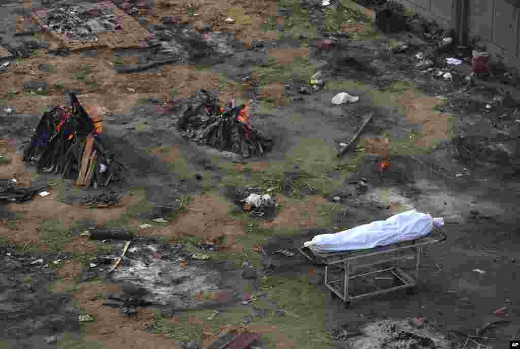 Multiple funeral pyres of people who died of COVID-19 are seen burning at a ground that has been converted into a crematorium for mass cremation of coronavirus victims, in New Delhi, India, April 21, 2021.