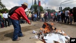 Protesters burn ballot boxes and ballots in the city of Oaxaca, Mexico, June 7, 2015.