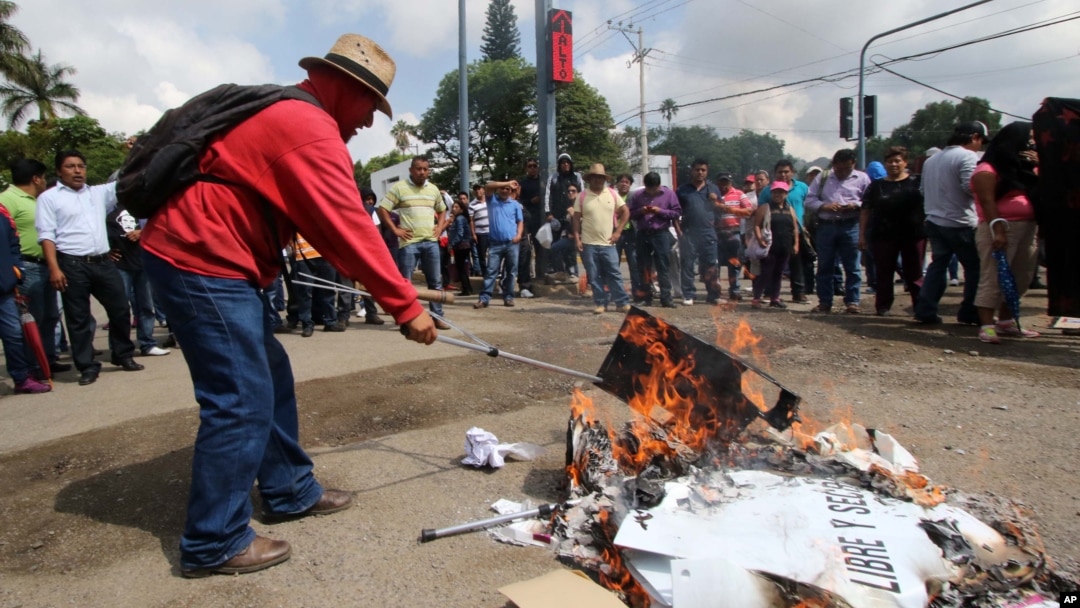 Para pengunjuk rasa membakar kotak-kotak suara di Oaxaca, Meksiko (7/6). (AP/Luis Alberto Hernandez)