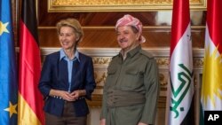 President of the Kurdish Autonomous Region in North Iraq Masoud Barzani, right, and German Defense Minister Ursula von der Leyen pose for media during their meeting in Erbil, Iraq, Sept. 25, 2014.