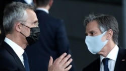 U.S. Secretary of State Antony Blinken, right, and NATO Secretary General Jens Stoltenberg wear protective masks as they prepare to stand with NATO foreign ministers for a socially distanced group photo during a meeting of NATO foreign ministers at…