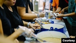 Staff and volunteers hand out meals at the Pit Stop Community Café in Kuala Lumpur, Malaysia. (Courtesy - Pit Stop Community Café)