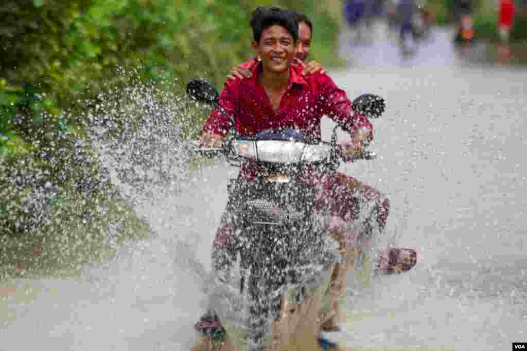 Local people ride a motorbike through a flooded road in Spean Tmor commune, Dangkoa district, Phnom Penh, Cambodia, on Oct. 14, 2020. (Malis Tum/VOA Khmer)