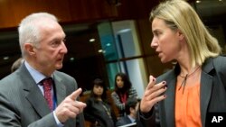 EU Counter-Terrorism chief Gilles de Kerkhove, left, gestures while speaking with European Union High Representative Federica Mogherini during a meeting of EU foreign ministers in Brussels, Jan. 19, 2015. 