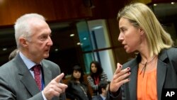 Kepala kontra terorisme Uni Eropa, Gilles de Kerkhove (kiri) berbicara dengan pejabat Uni Eropa Federica Mogherini di sela pertemuan Menlu UE di Brussels, Belgia (19/1).