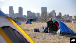FILE - Terry cleans out his tent at a large homeless encampment near downtown St. Louis. Jan. 27, 2015. The gap between the haves and have-nots in the United States grew last year.