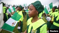 A school girl holds a Nigerian flag as she joins a parade marking Nigeria's 54th Independence Day in Lagos October 1, 2014.