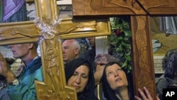Christians carry crosses inside the Church of the Holy Sepulcher during a Good Friday procession in Jerusalem's Old City, Apr 22 2011