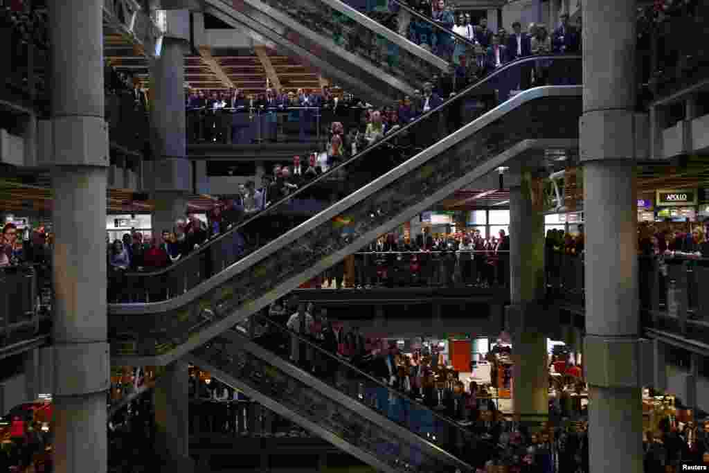 Staff members stand for a poppy drop during a Remembrance Service at the Lloyd&#39;s building in the city of London, Britain.