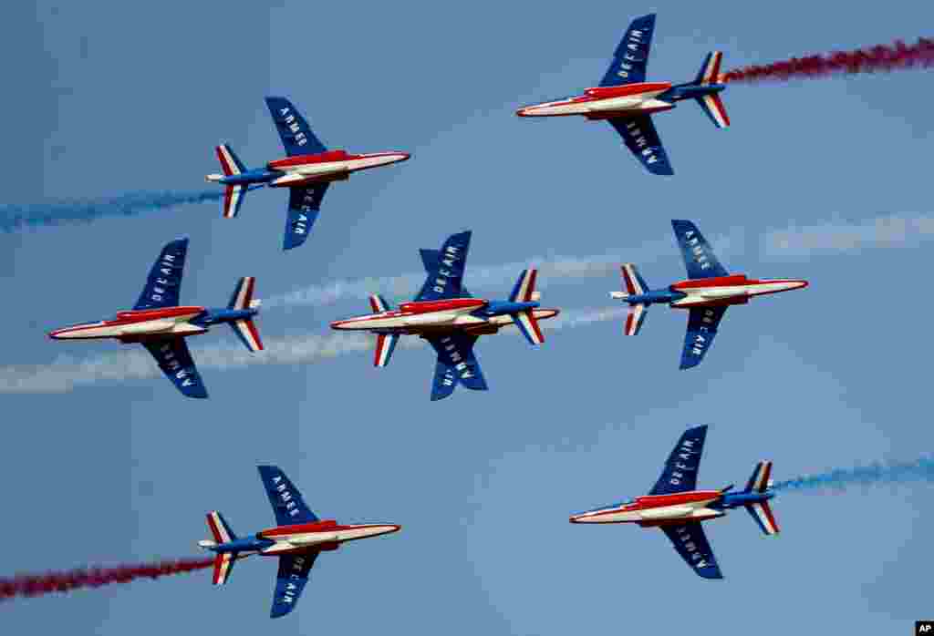 French aircrafts of the Patrouille de France spray colored smoke during a performance on the opening day of the Dubai Airshow in Dubai, United Arab Emirates.