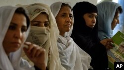 A group of Afghan women listen attentively how to count votes and seal them away to keep the country's first ever presidential election as fair as possible.