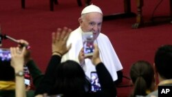 FILE - Pope Francis arrives in the Paul VI Hall at the Vatican for an audience with the participants in the 3rd International Meeting of Chorales, Nov. 24, 2018.