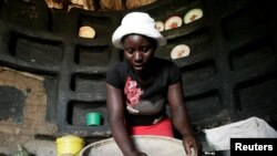 FILE - A woman prepares sorghum for food at her home in drought-hit Masvingo, Zimbabwe, June 1,2016. 