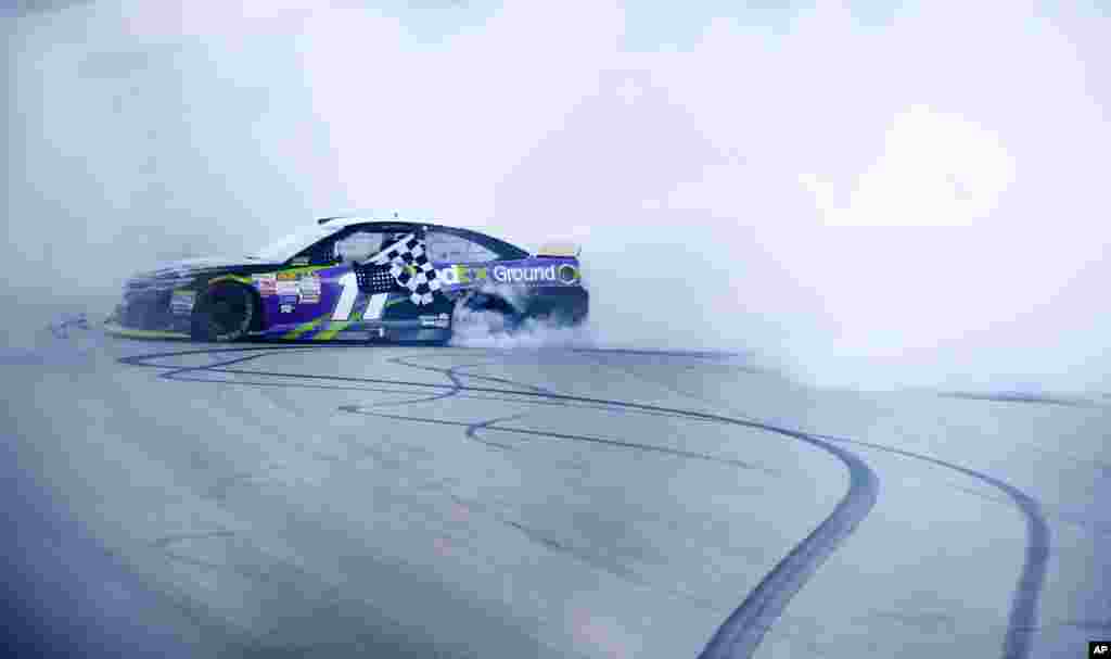 Denny Hamlin melakukan aksi &quot;burnout&quot; seusai menang balapan otomotif NASCAR Sprint Cup Series di sirkuit Chicagoland Speedway di negara bagian Illinois, Amerika, 20 September 2015.