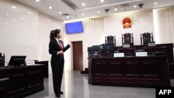 资料照片：一名中国人民最高法院的工作人员站在法庭内向参观者做介绍。（2018年12月20日）
