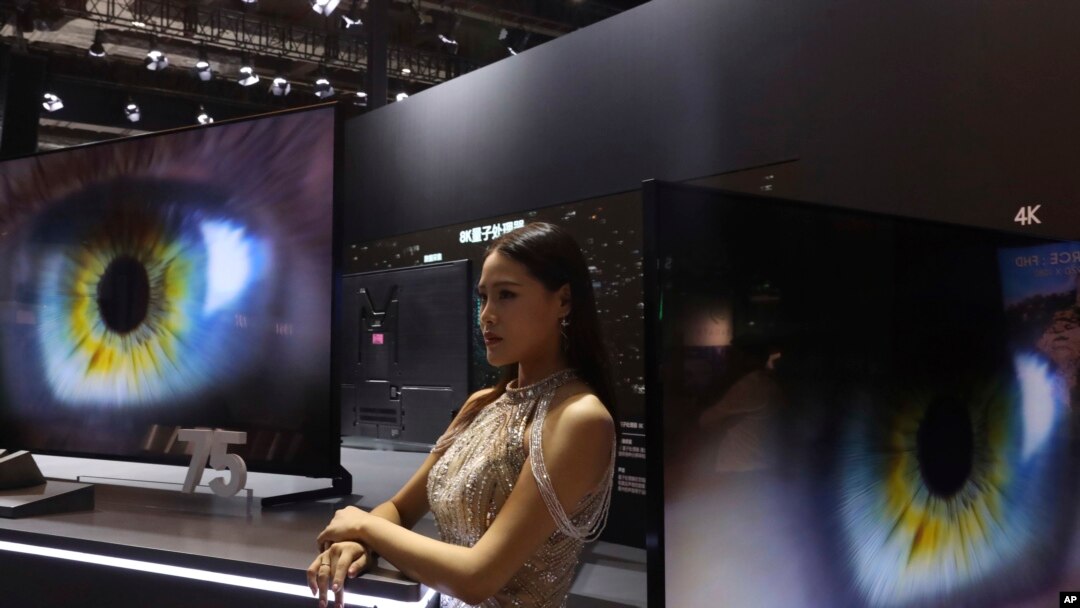 Seorang model berdiri di samping layar lebar Samsung di sebuah pameran internasional di Shanghai, 6 November 2018.