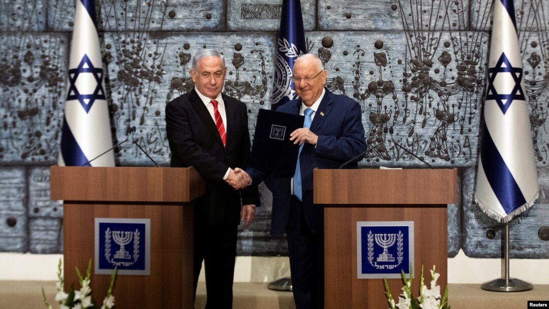 Israeli President Reuven Rivlin gives Israeli Prime Minister Benjamin Netanyahu a file during a nomination ceremony at the President's residence in Jerusalem, Sept. 25, 2019. 