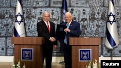 Israeli President Reuven Rivlin gives Israeli Prime Minister Benjamin Netanyahu a file during a nomination ceremony at the President's residence in Jerusalem, Sept. 25, 2019. 