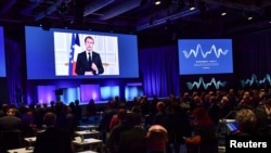 France's President Emmanuel Macron appears on a screen at the Malmo International Forum on Holocaust Remembrance and Combating Antisemitism, in Malmo, Sweden, October 13, 2021. 