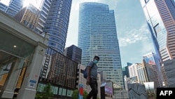 新加坡金融商业区一名男子戴口罩穿行（2020年4月14日）