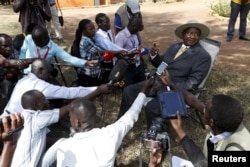 FILE - Uganda's incumbent President Yoweri Museveni speaks to the media soon after casting his vote at a polling station during the presidential elections in Kirihura, in western Uganda, Feb. 18, 2016.